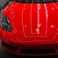 Błyszczący czerwony lakier Porsche i butelka preparatu SWAG Final Inspect. Idealny do tego, czym odtłuścić lakier przed polerowaniem.