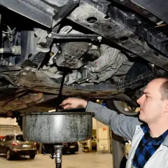 Mechanik spuszcza stary olej z silnika. Zastanawiasz się, ile trwa wymiana oleju? Zazwyczaj to szybka czynność.