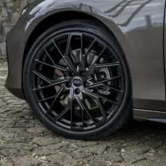 Błyszczące, czarne felgi Audi z homologacją opon Michelin Pilot Sport 5 na kamiennej nawierzchni.