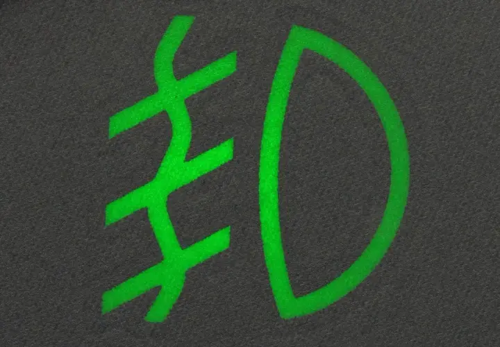 Zielony symbol przeciwmgielny na ciemnym tle.