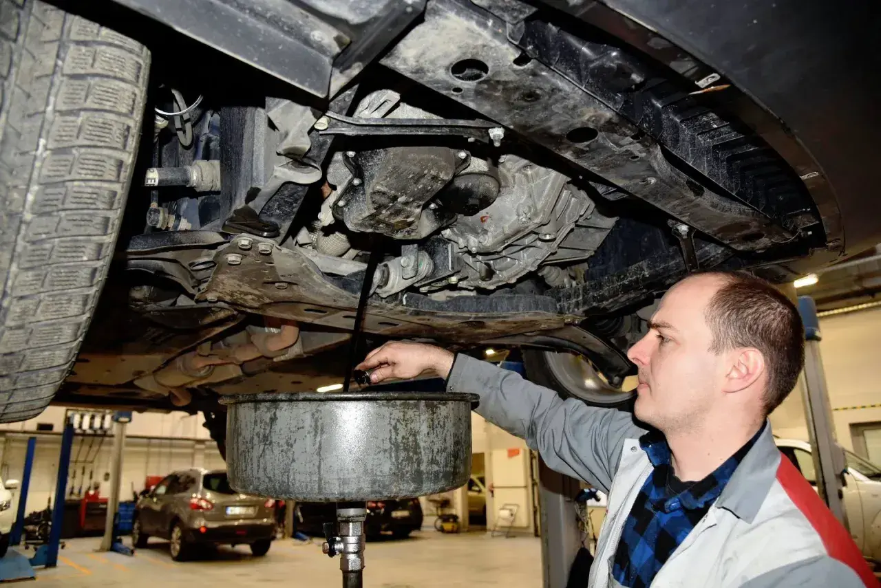 Mechanik spuszcza stary olej z silnika. Zastanawiasz się, ile trwa wymiana oleju? Zazwyczaj to szybka czynność.