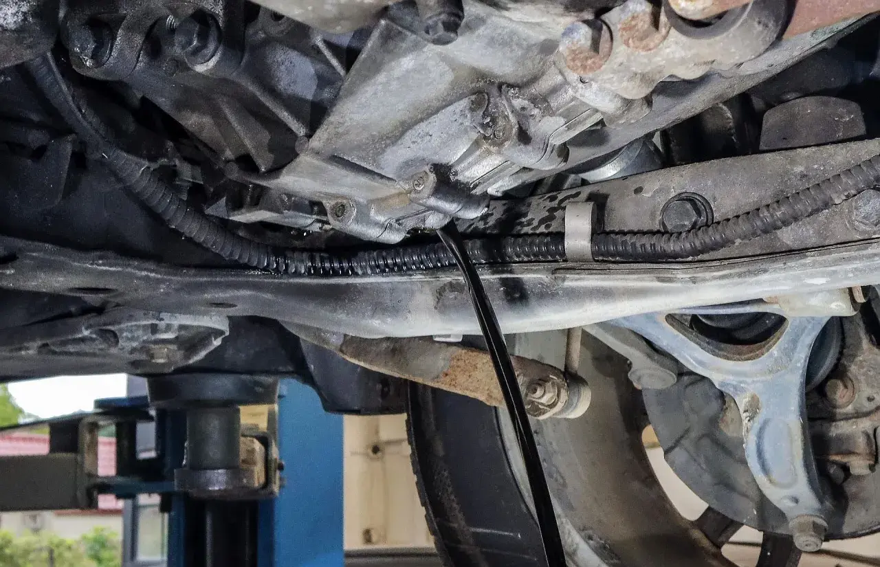 Podczas wymiany oleju w skrzyni manualnej, czarny pręt wchodzi do mechanizmu, by spuścić zużyty płyn.