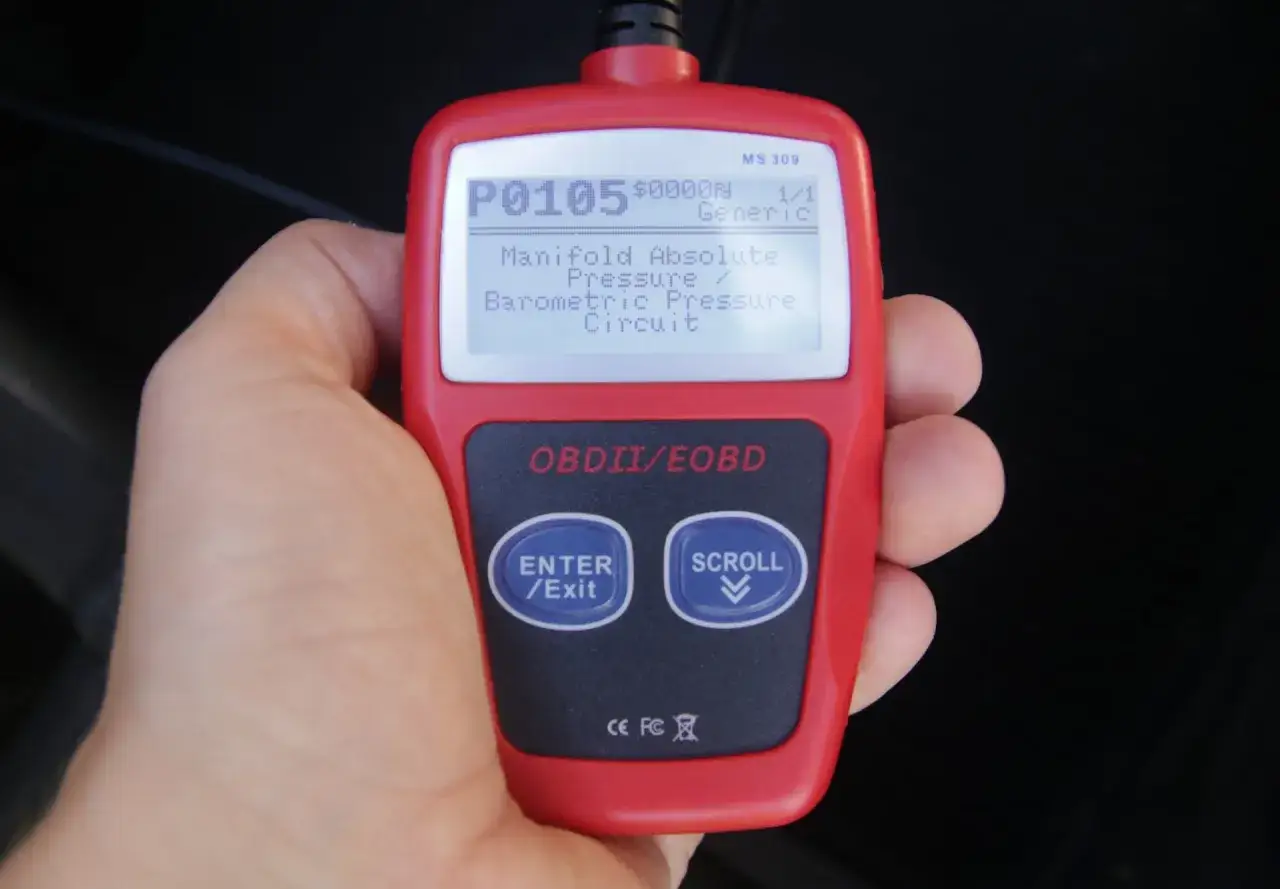 Czerwony skaner OBDII pokazuje kod błędu P0105: Manifold Absolute Pressure / Barometric Pressure Circuit. To część listy kodów błędów.