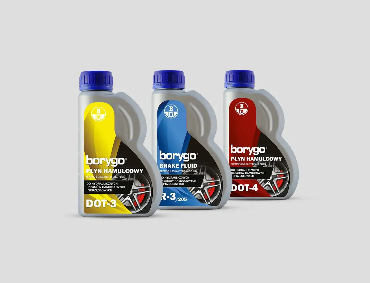 Trzy butelki płynu hamulcowego Borygo: DOT-3 (żółty), DOT-4 (czerwony) i jeden z oznaczeniem R-3/205 (niebieski).