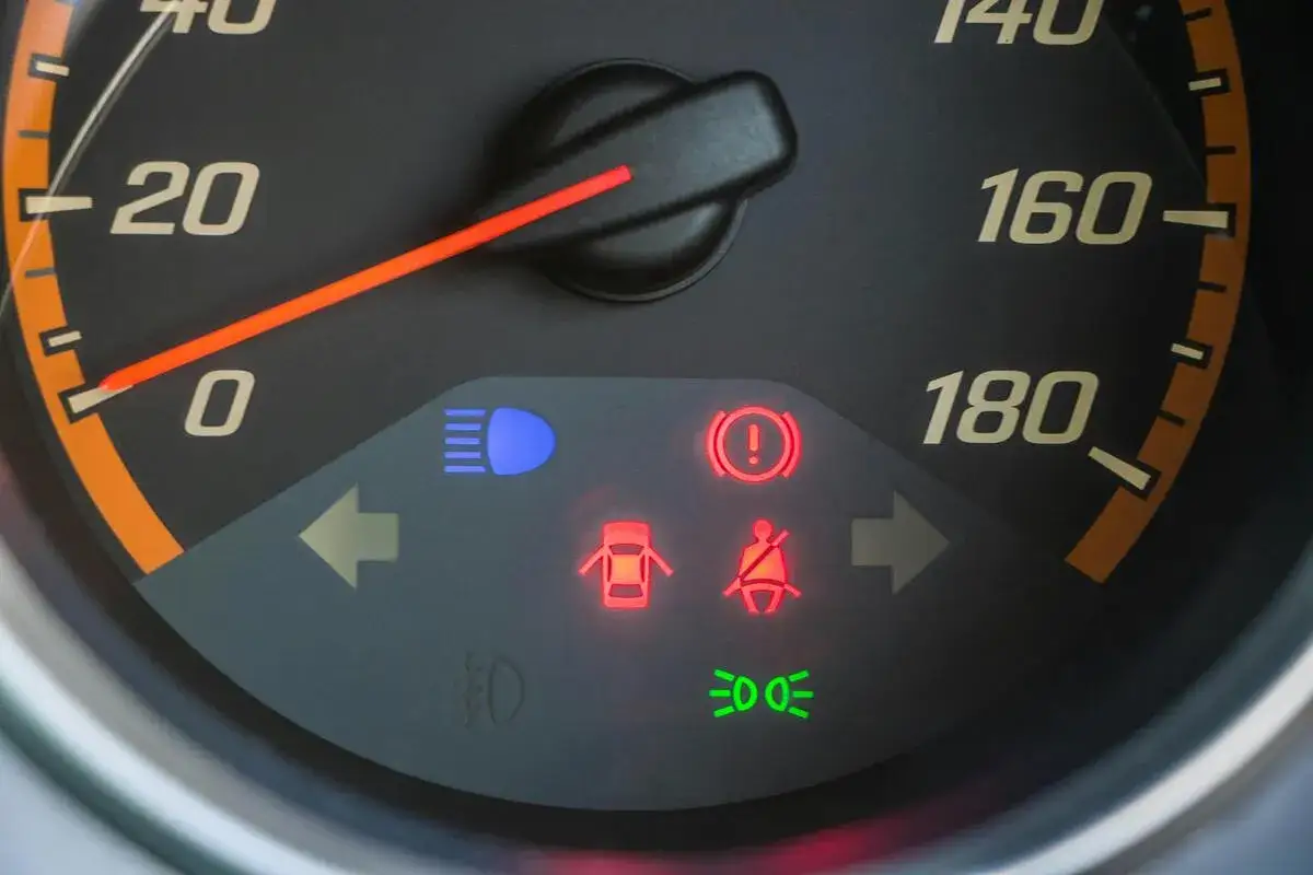 Kontrolki na desce rozdzielczej: światła, hamulec ręczny, otwarte drzwi, pasy bezpieczeństwa, światła drogowe. System OBD informuje o stanie pojazdu.